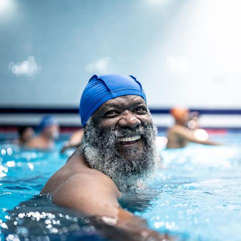 A portrait of an older adult in the swimming pool.