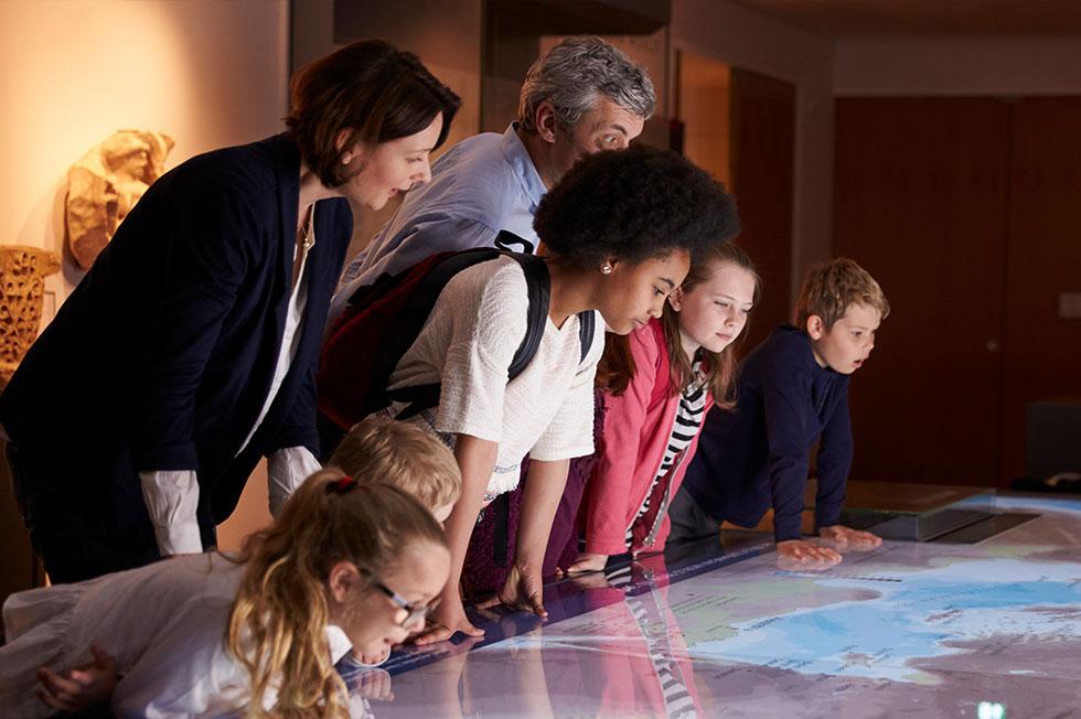 Group of students and adults looking at a map.