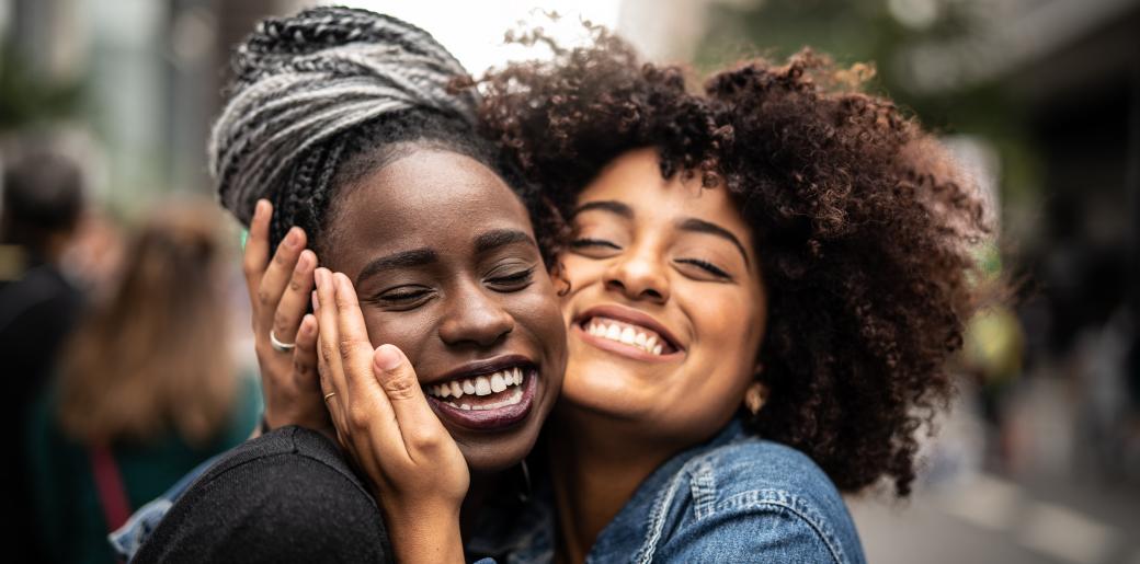 Two youth embrace, smiling