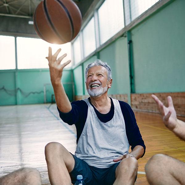 Gros plan d’un groupe d’aînés se relaxant après avoir joué au basket-ball.