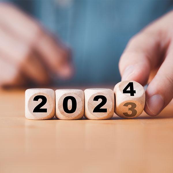 Mains changeant des cubes de bois de l’année 2023 à 2024.