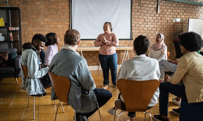 Young woman with special needs talking in a group meeting.