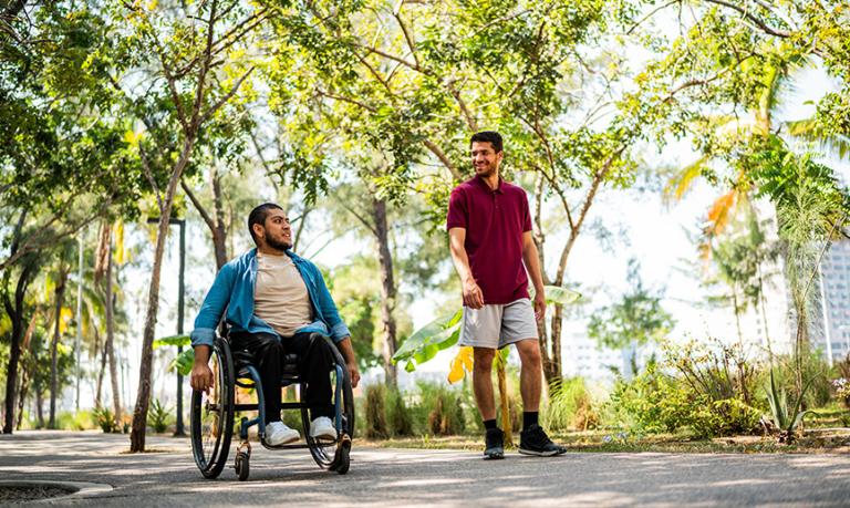 Friends talking in a public park on an accessible pathway